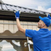 man installing house roof rain gutter system