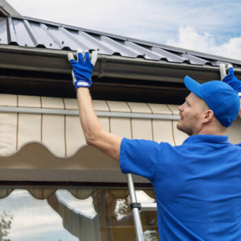 man installing house roof rain gutter system